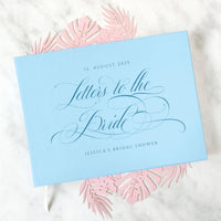 Personalized “Letters to the Bride” book with baby blue vegan leather cover, engraved date, and name. A heartfelt bridal shower gift where guests can write advice, wishes, and letters, creating a timeless keepsake for the bride-to-be.