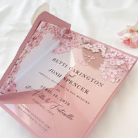 Clear acrylic wedding invitation with sakura cherry blossom design, blush envelope, and wax seal.