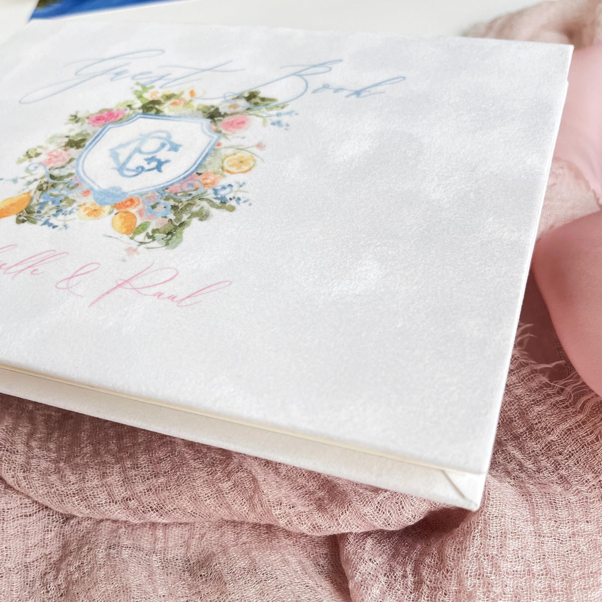 White velvet guest book with painted watercolor monogram and floral details.