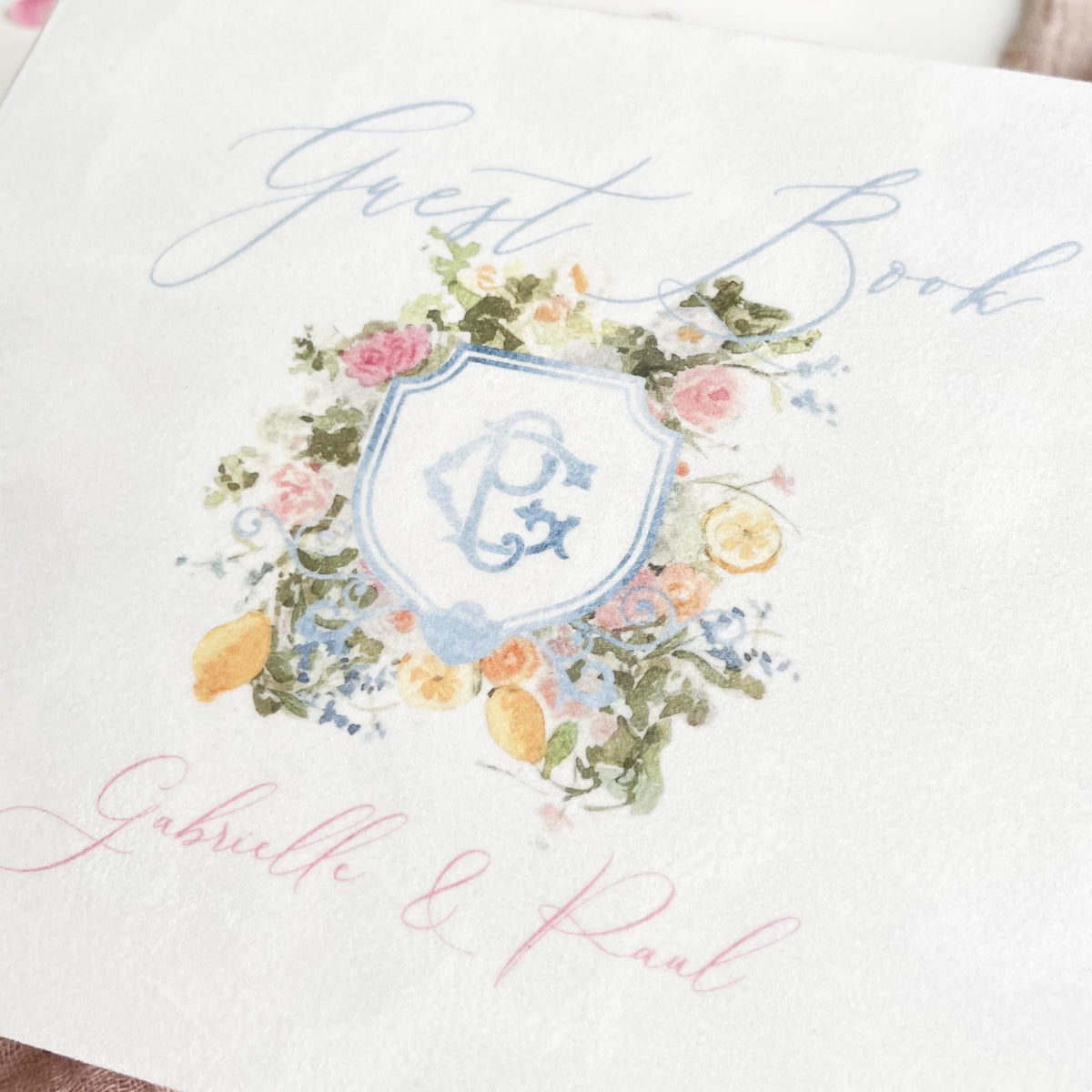 Exquisite white velvet guest book with painted watercolor monogram and floral details.
