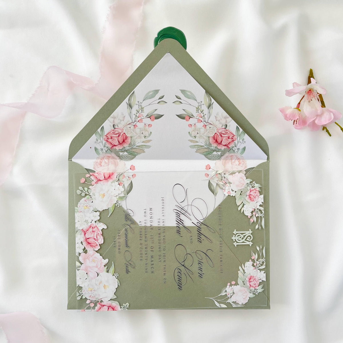 Luxurious clear acrylic wedding invitation with rose print, sage envelope and liner, finished with a monogram wax seal.