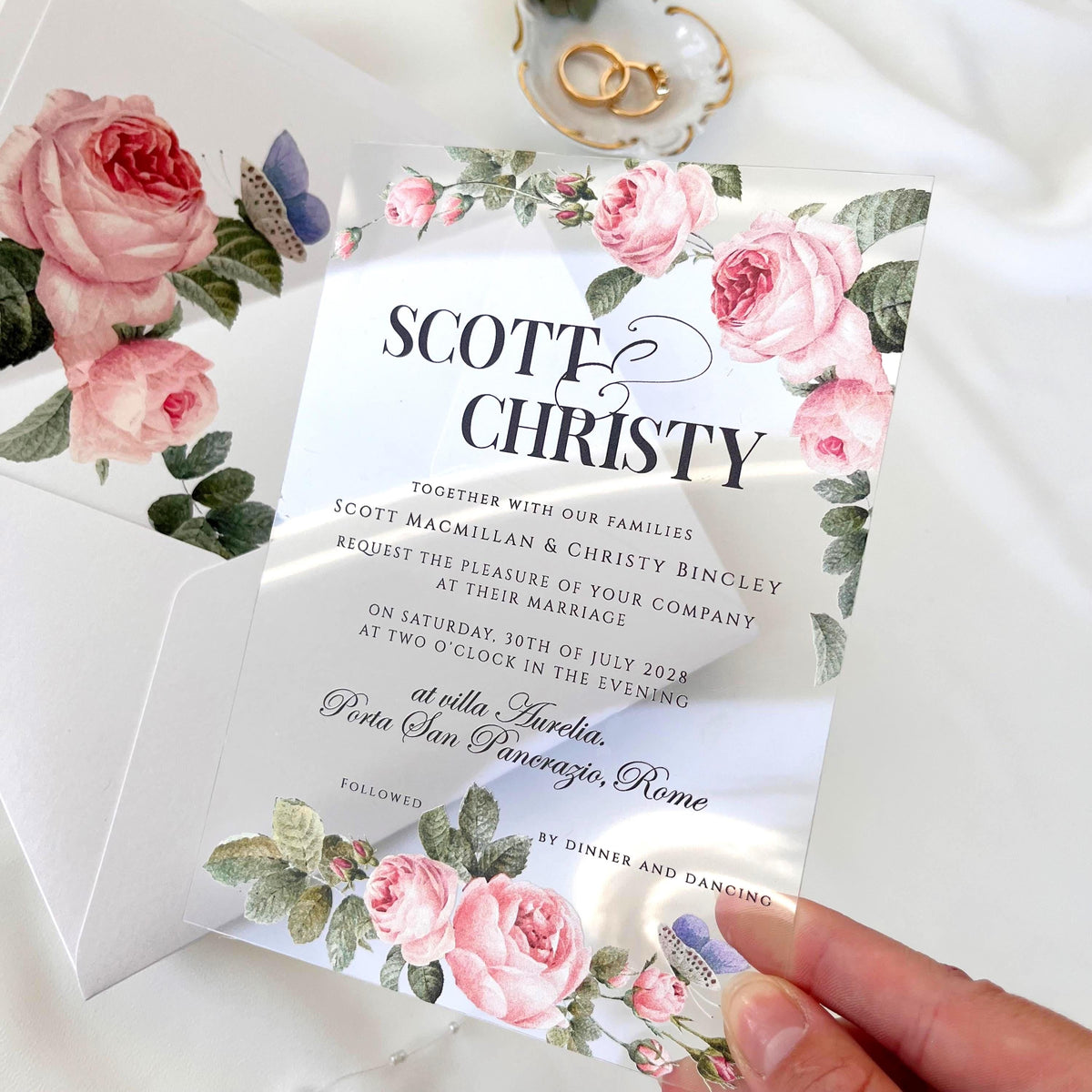 Clear acrylic wedding invitation with delicate rose design, paired with white envelope and rose-printed liner.