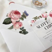 Floral acrylic wedding invite with roses, white envelope, printed liner, and wax seal with monogram and rose detail.