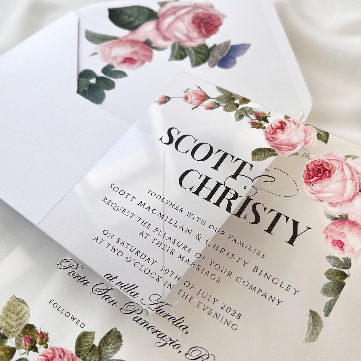 Elegant clear acrylic invitation with rose print, white envelope, and custom wax seal featuring rose motif.
